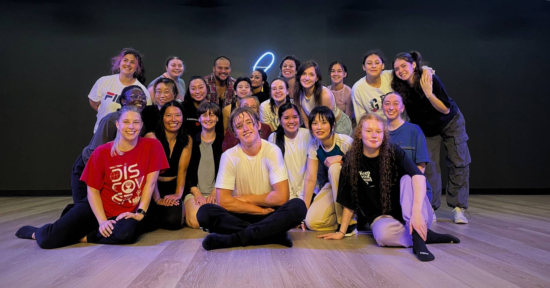 A party group posing under the neon 8 at House of Eights