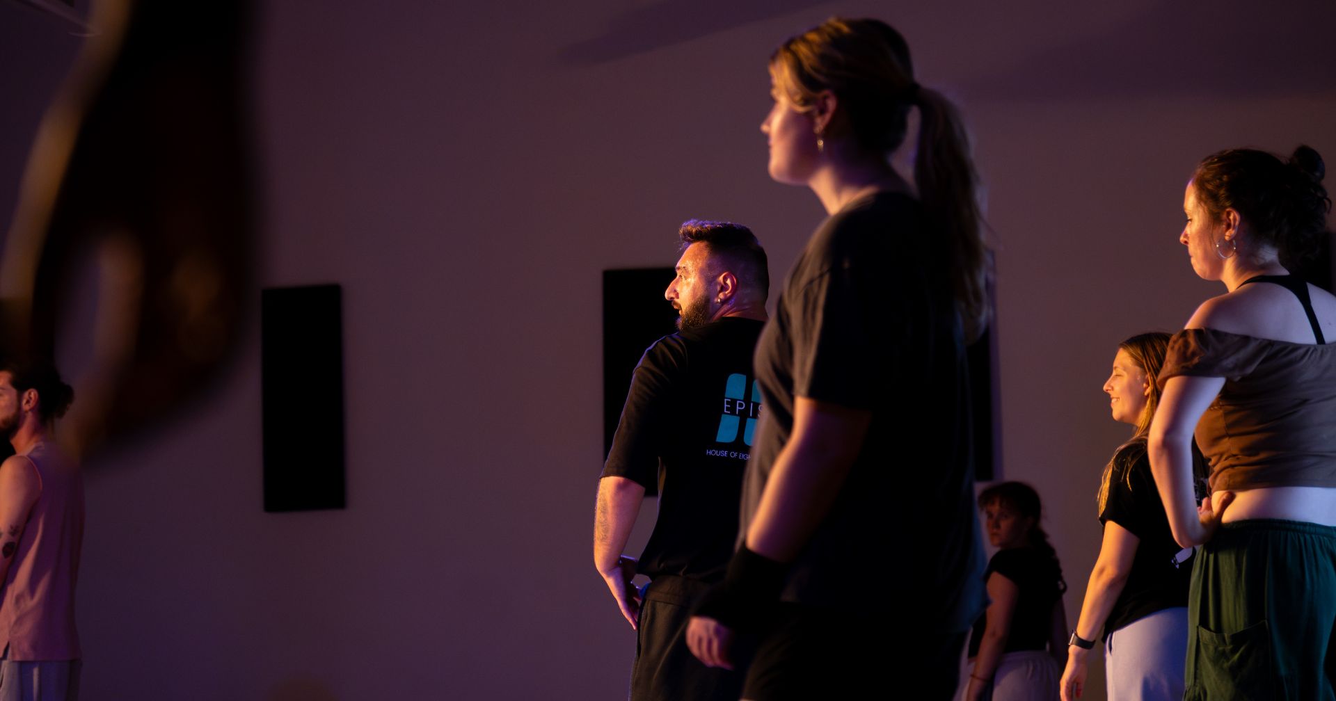 A team learning a routine under warm lights at the studio